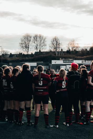 Eftersom texten handlar om vikten av att ha gemensamma samlingar för utvärdering och samtal efter tävlingar passar det bra att inkludera en bild på ett lag som pratar i grupp.